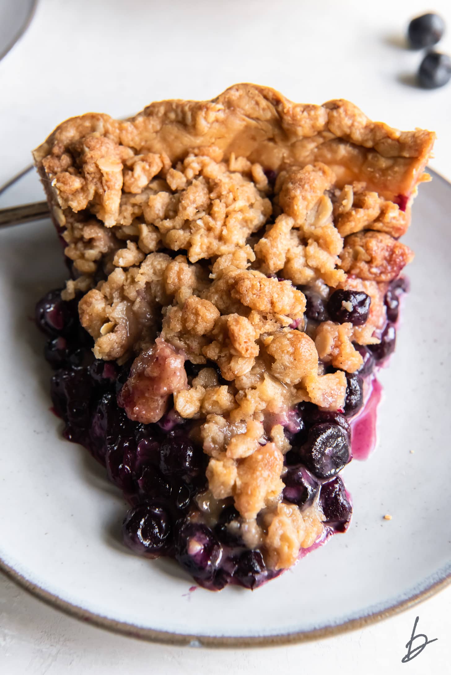 slice of blueberry crumble pie on a grey plate