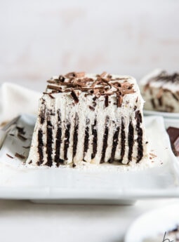 inside of an icebox cake showing vertical layers of chocolate wafers and whipped cream and chocolate shavings on top