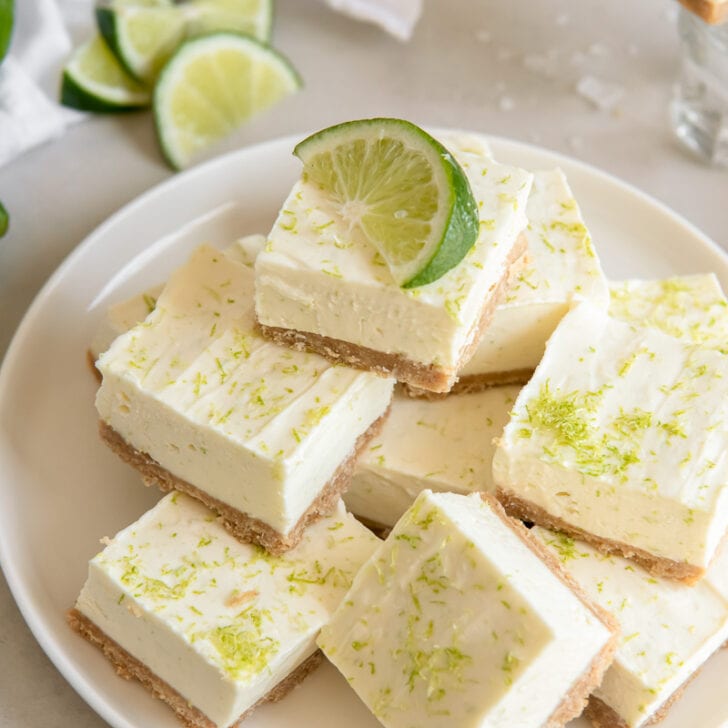 plate of margarita cheesecake bars with wedge of lime on top
