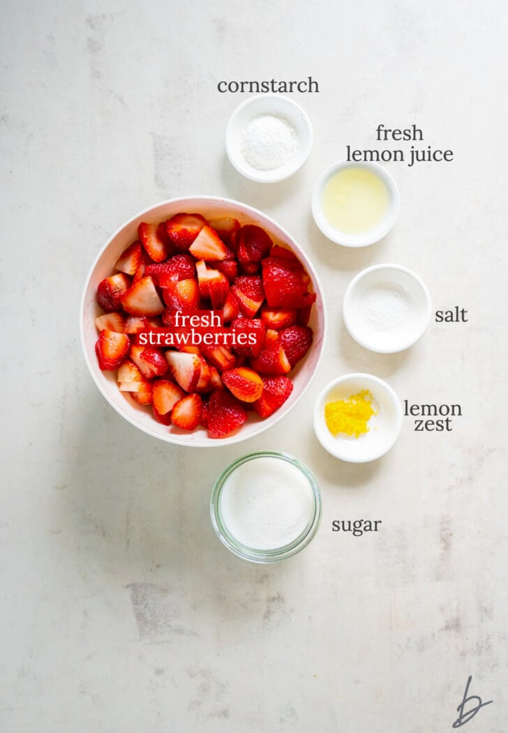 strawberry cobbler filling ingredients in bowls labeled with text