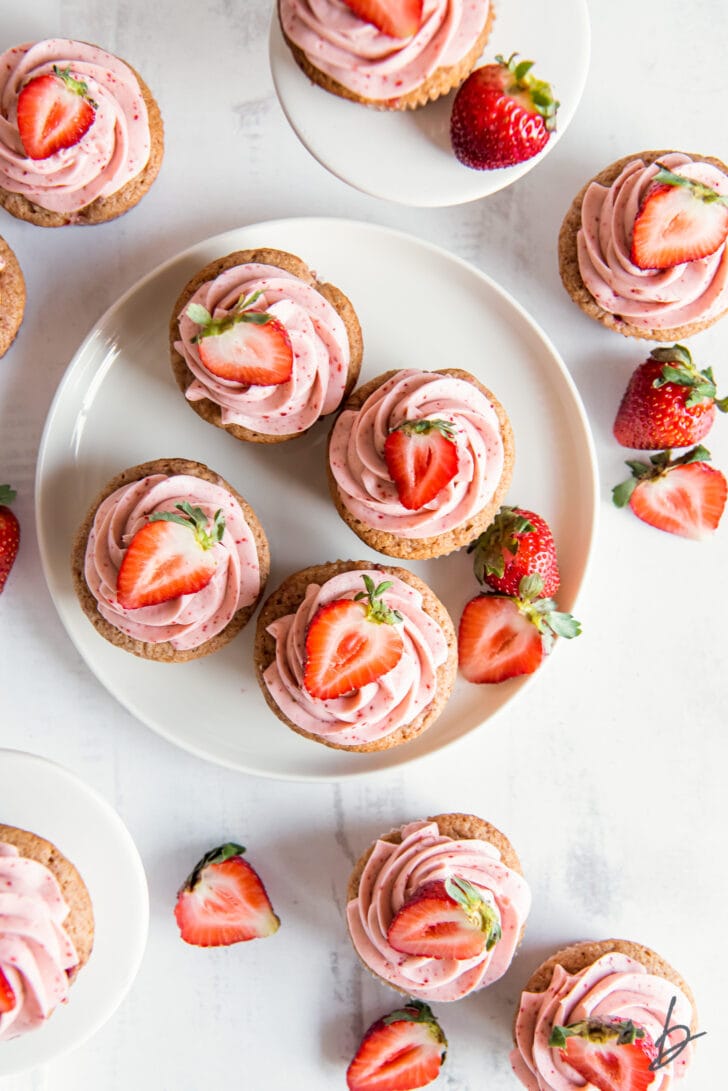 tops of strawberry cupcakes with strawberry cream cheese frosting and strawberry halves