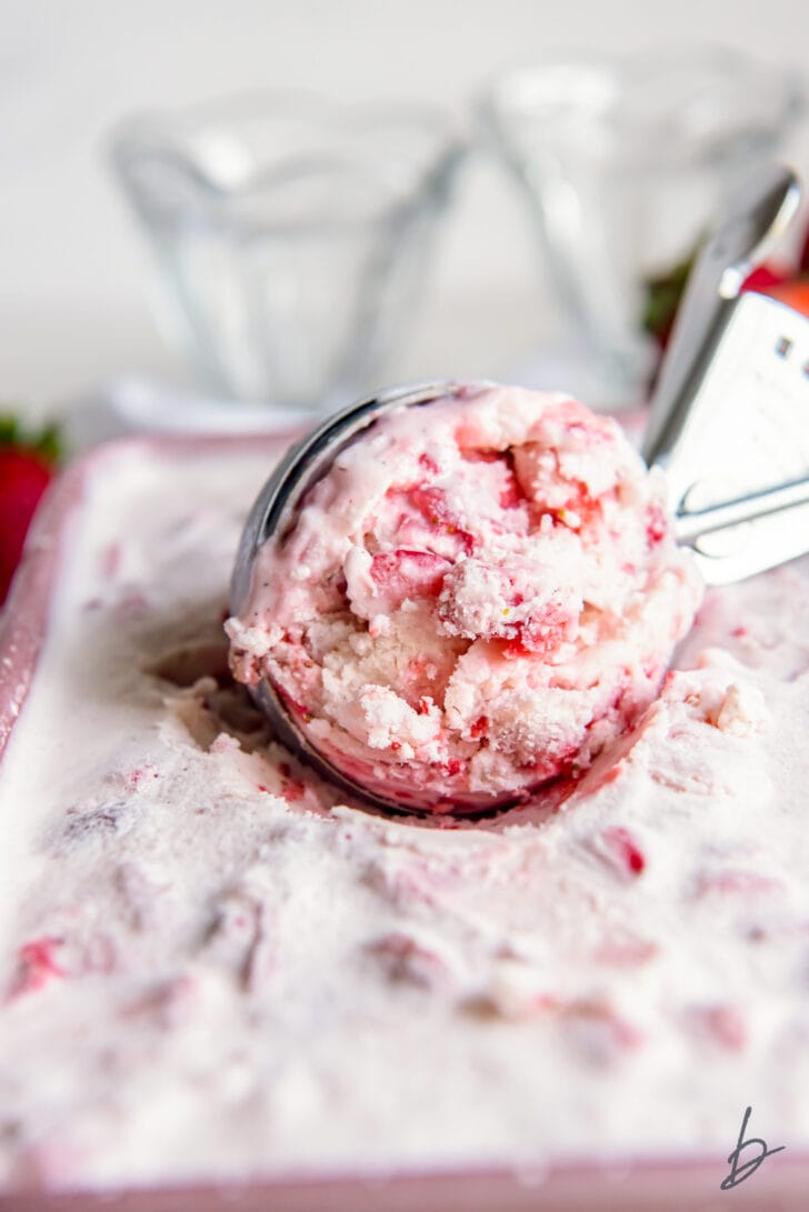 ice cream scoop scooping strawberry ice cream out of pan