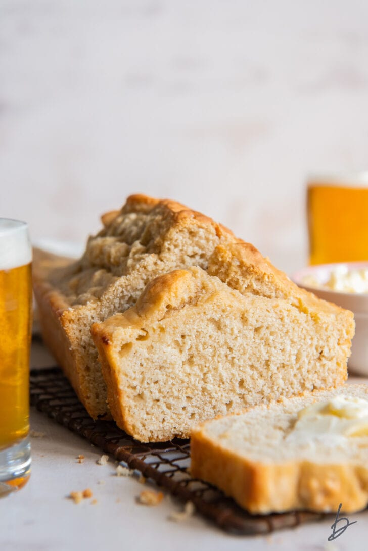 slice of beer bread up against loaf next to glass of beer