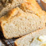 beer bread with slice cut off end and butter spread on slice