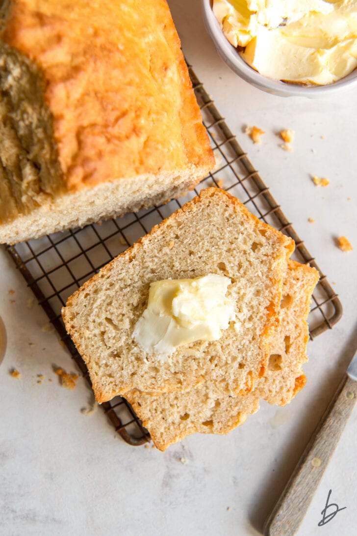butter spread on slice of beer bread on small rectangle wire cooling rack