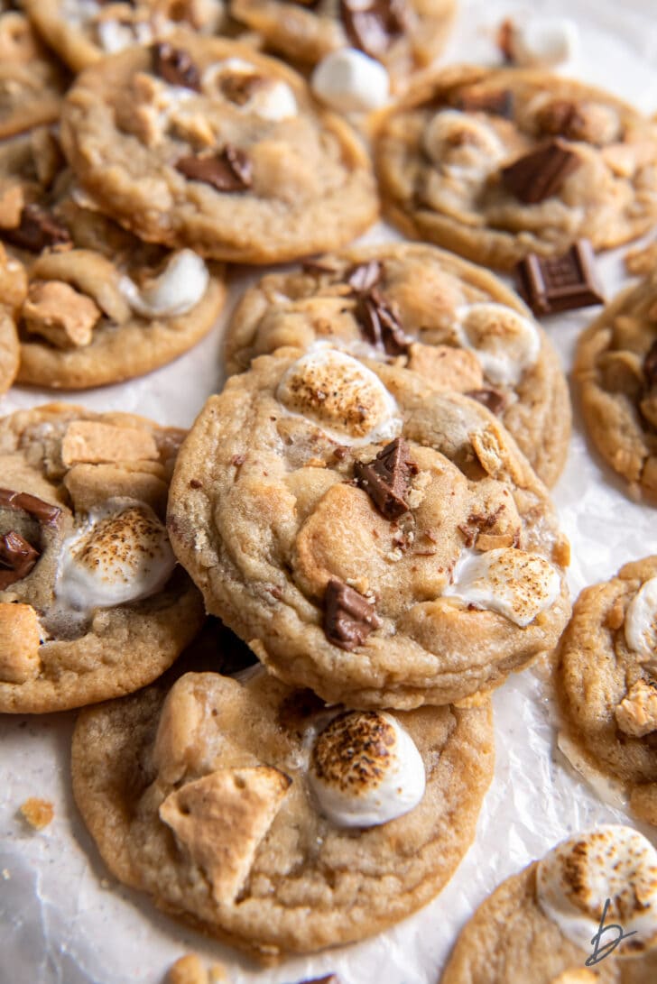 pile of smores cookies with toasted marshmallows, chopped chocolate and graham cracker bits