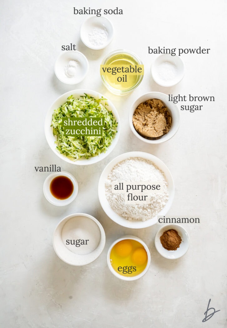 zucchini bread muffins ingredients in bowls labeled with text