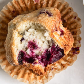 cherry muffin with a bite on open paper liner