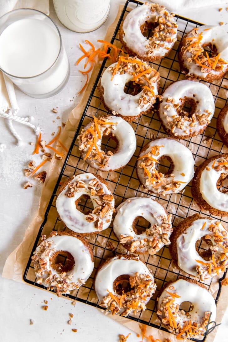 garnished and frosted carrot cake donuts on wire cooling rack