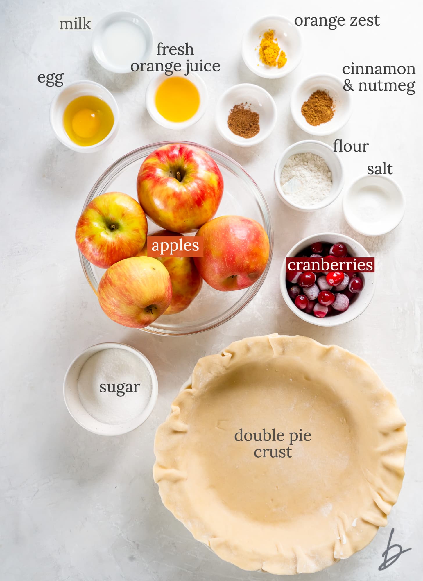 cranberry apple pie ingredients in bowls labeled with text.