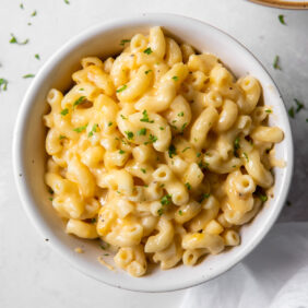 bowl of mac and cheese with sprinkle of parsley for garnish.