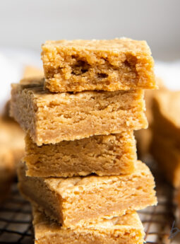 stack of peanut butter cookie bars and top bar has a bite.