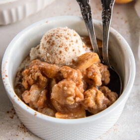 bowl of apple pear crisp with small scoop of ice cream.