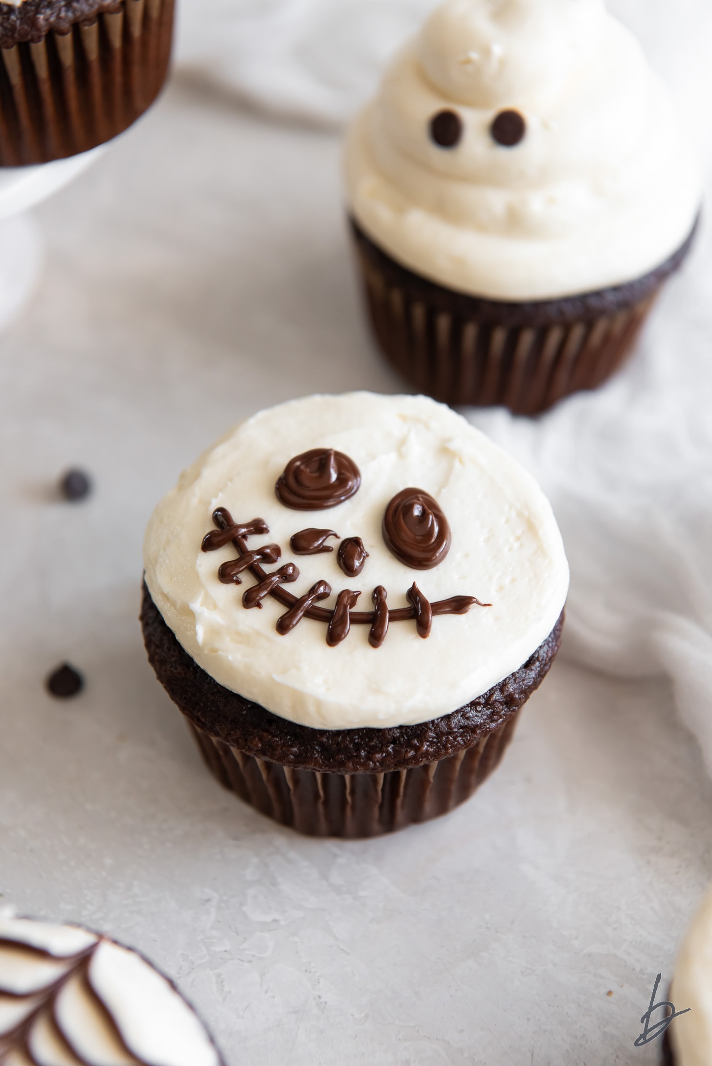 chocolate cupcake with vanilla frosting and decorated to look like skeleton face.