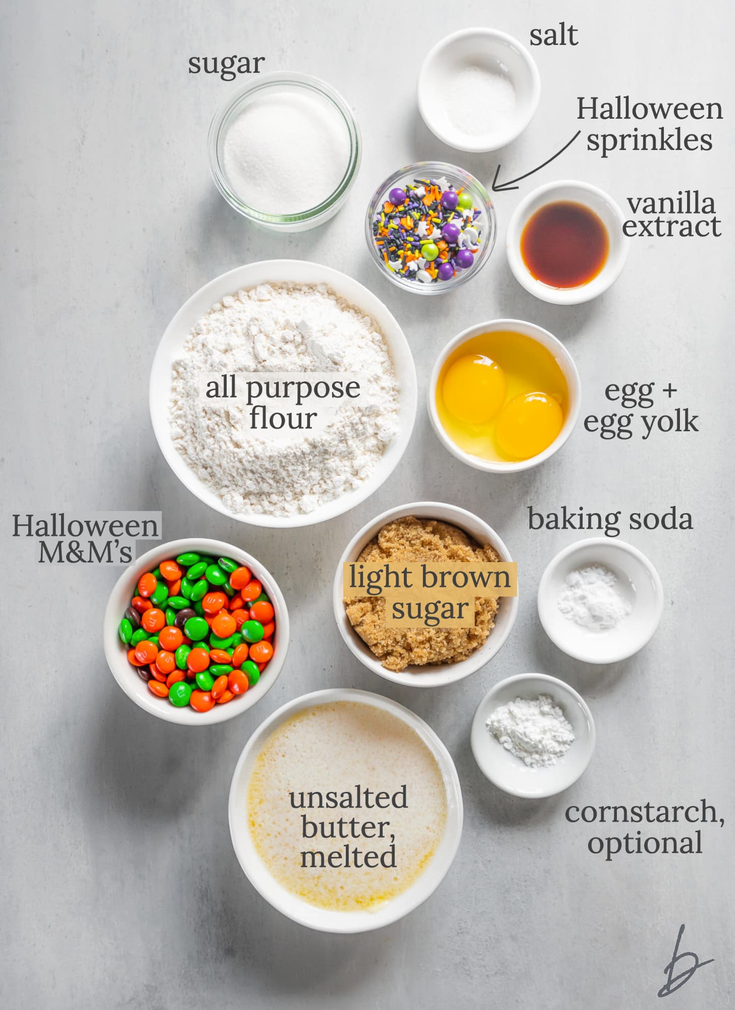 ingredients for halloween cookies in bowls labeled with text.