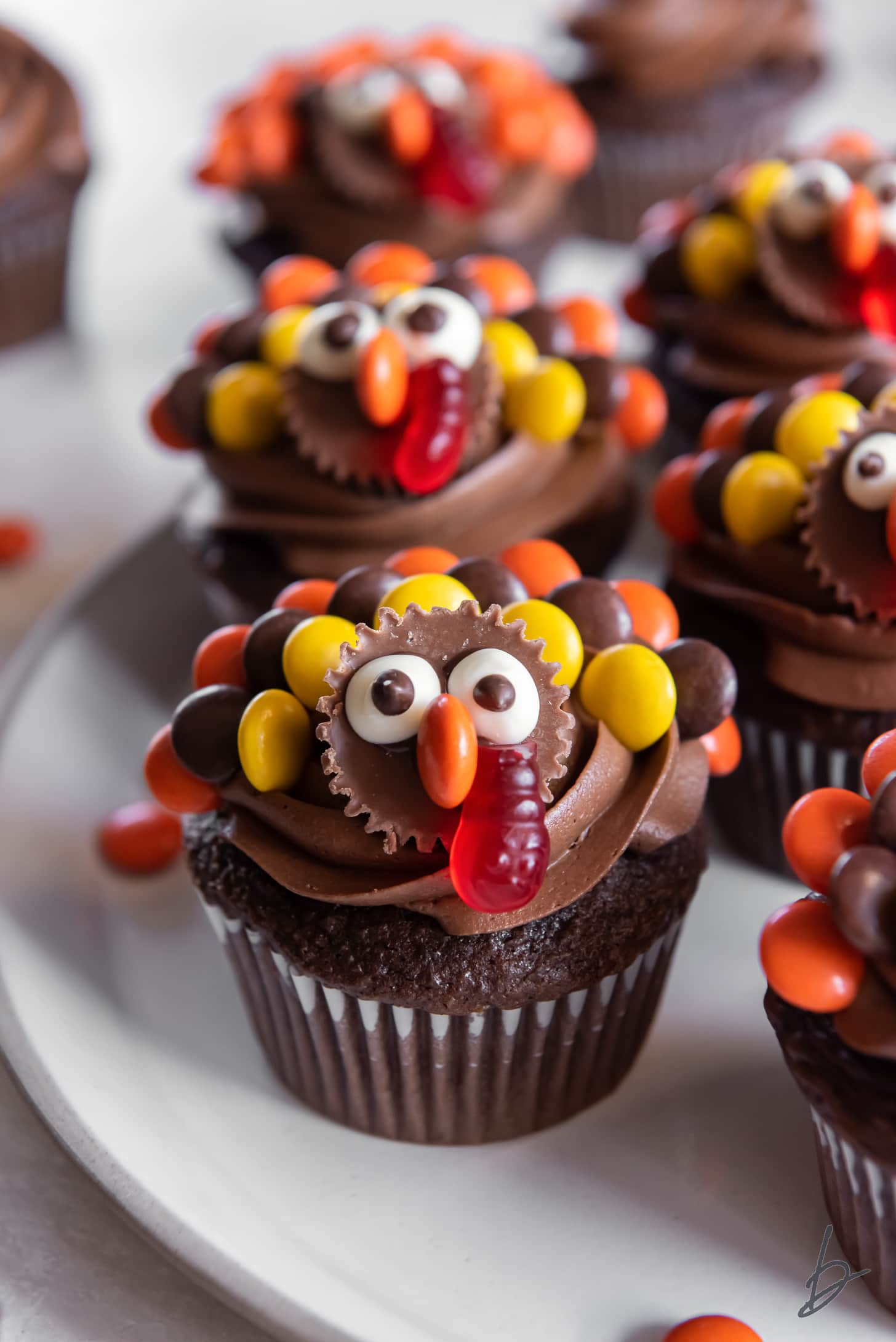 chocolate turkey cupcakes with reese's mini cup face and reese's pieces feathers.
