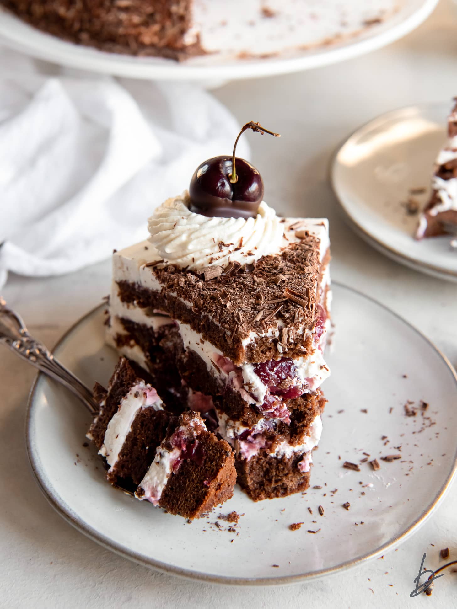 slice of black forest cake with fork holding a bite.