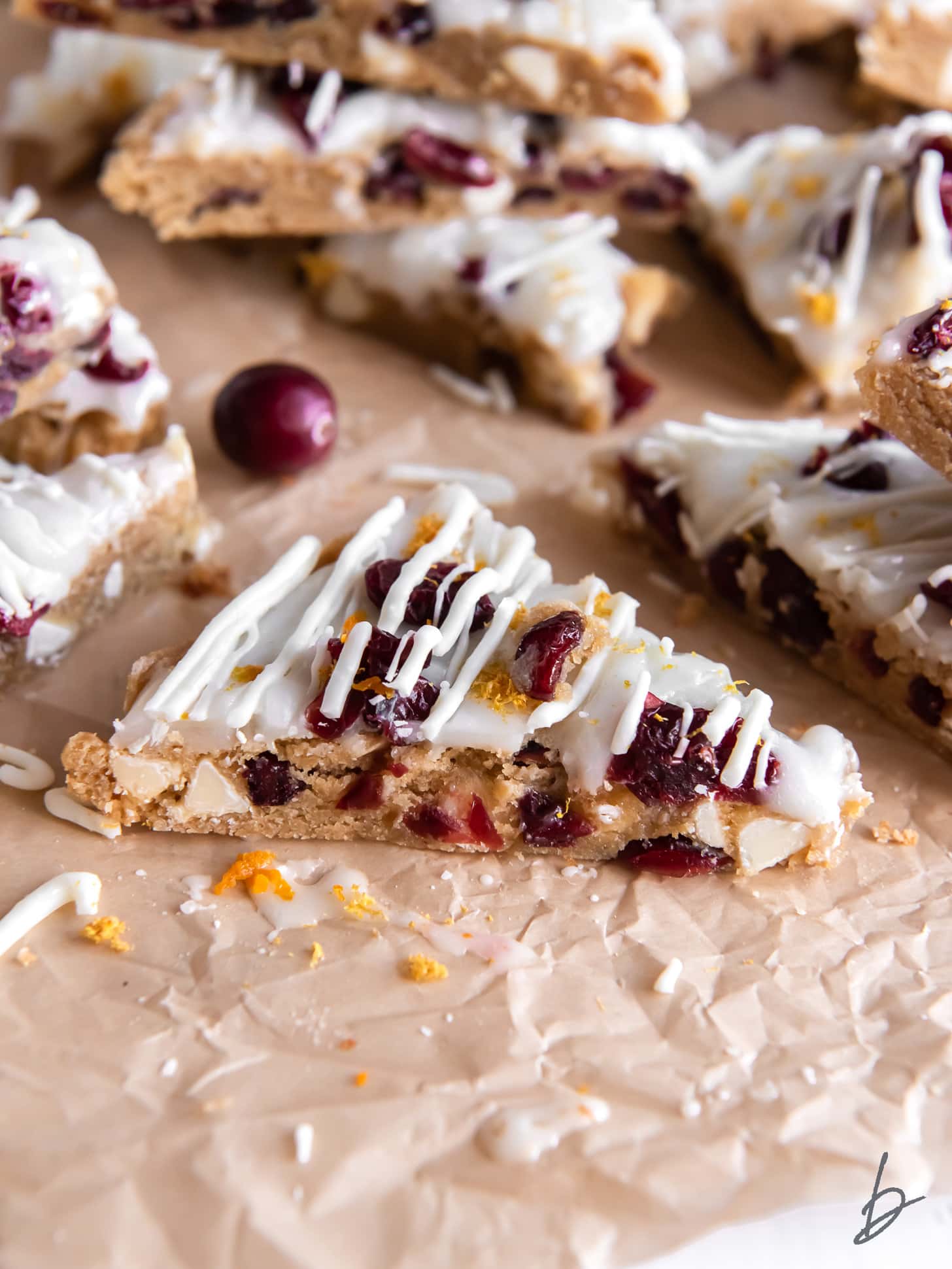 cranberry bliss bar triangle with dried cranberries and white chocolate drizzle.