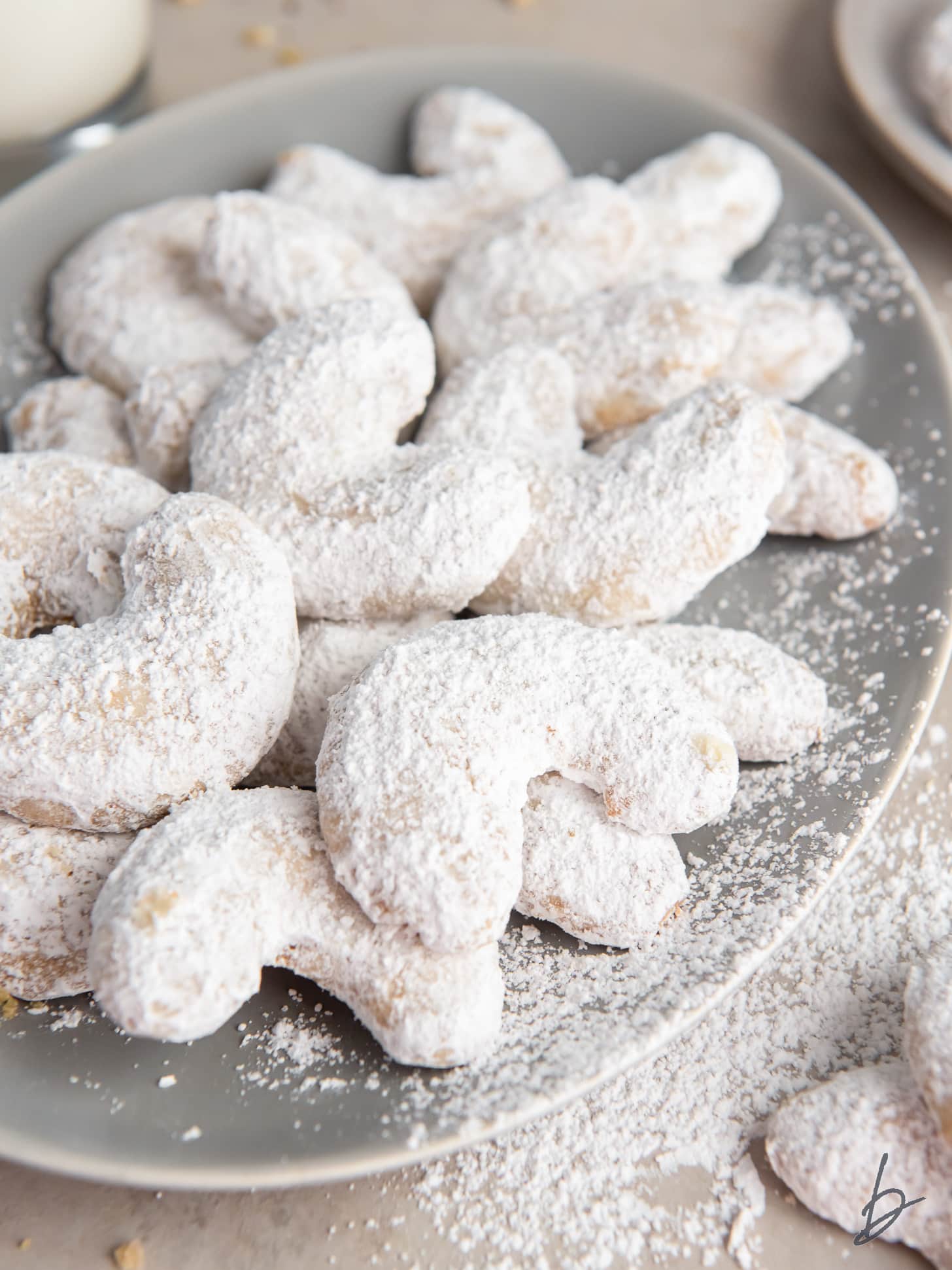 vanillekipferl with powdered sugar on a plate.