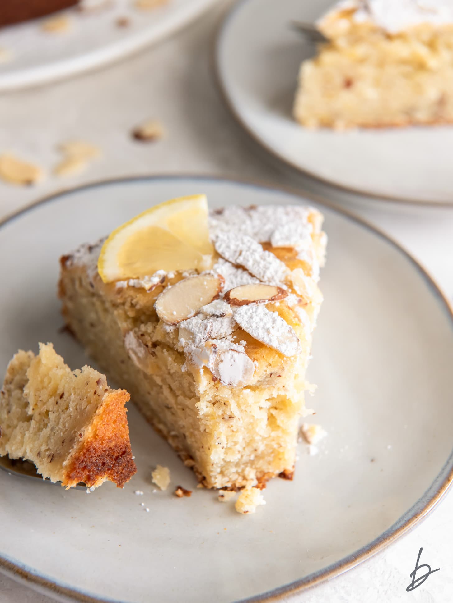 lemon ricotta cake slice with a fork holding a bite from the end.