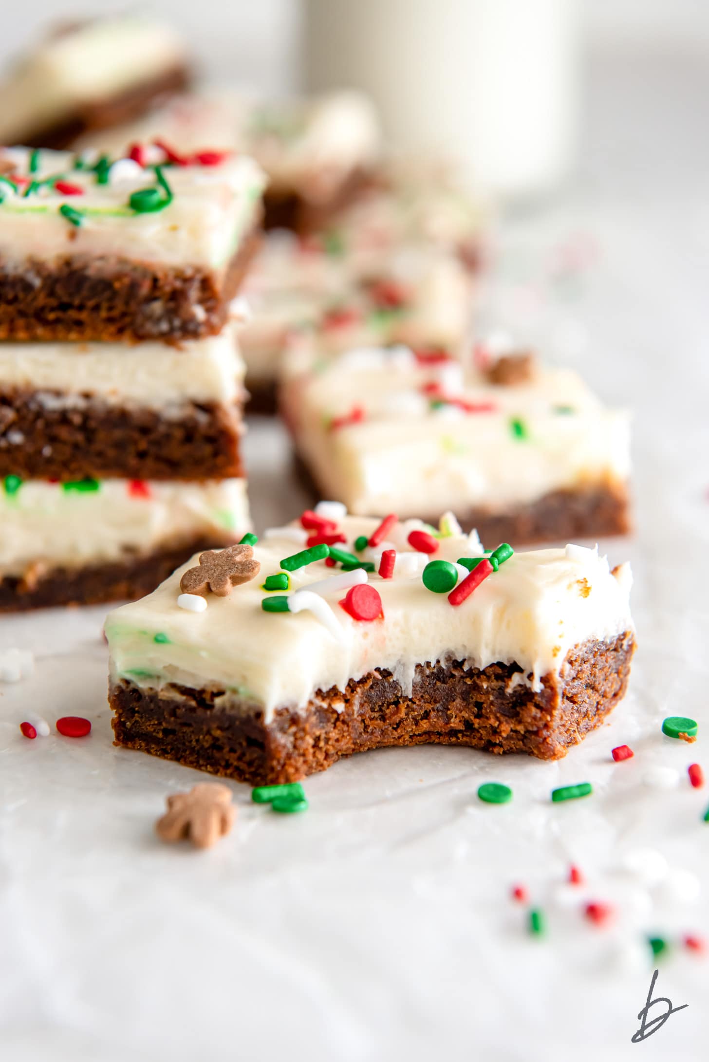 bite taken out of gingerbread cookie bar with cream cheese frosting.