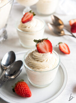 vanilla mousse in a glass jar with strawberry garnish.
