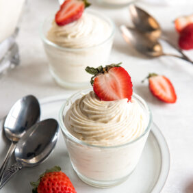 vanilla mousse in a glass jar with strawberry garnish.