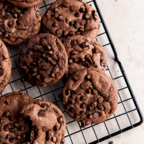 cooling rack with chocolate cake mix cookies with chocolate chips.