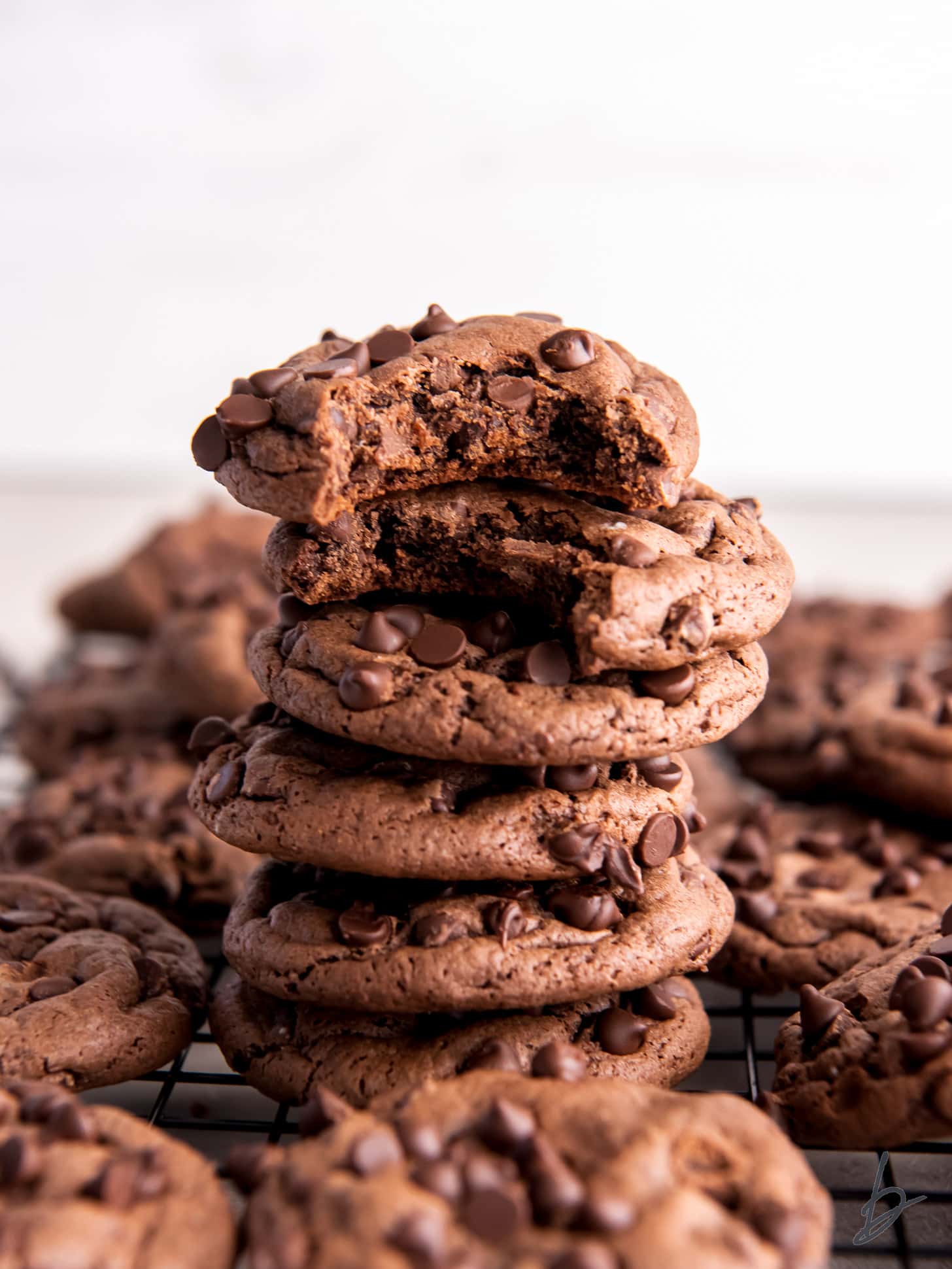 stack of chocolate cake mix cookies and top cookie with a bite.