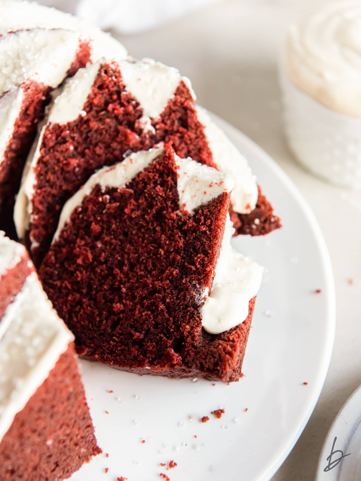 slices of red velvet pound cake leaning against the rest of the bundt cake.