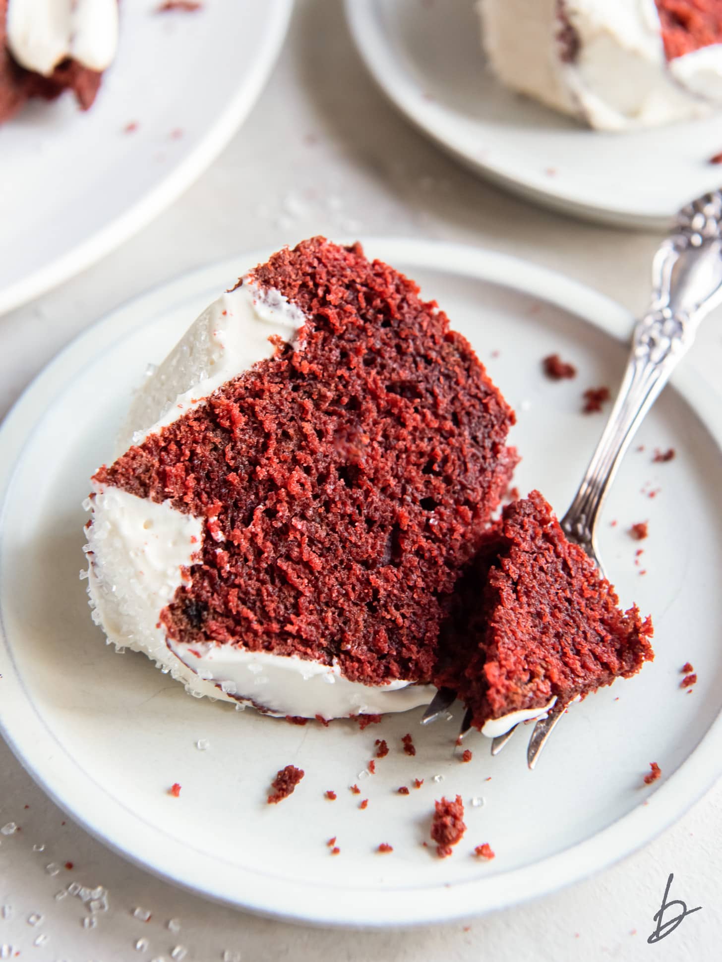 red velvet pound cake slice on plate with fork taking a bite.