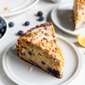 slice of blueberry buckle coffee cake with streusel and glaze.