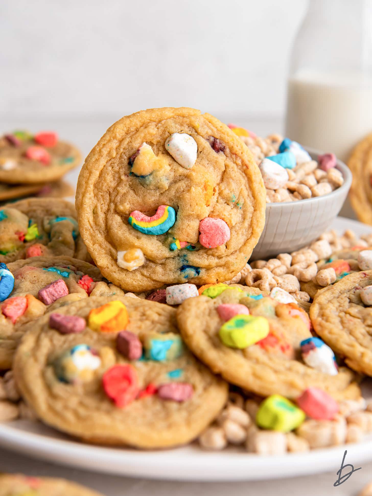 lucky charms cookie propped up on plate with more cookies.