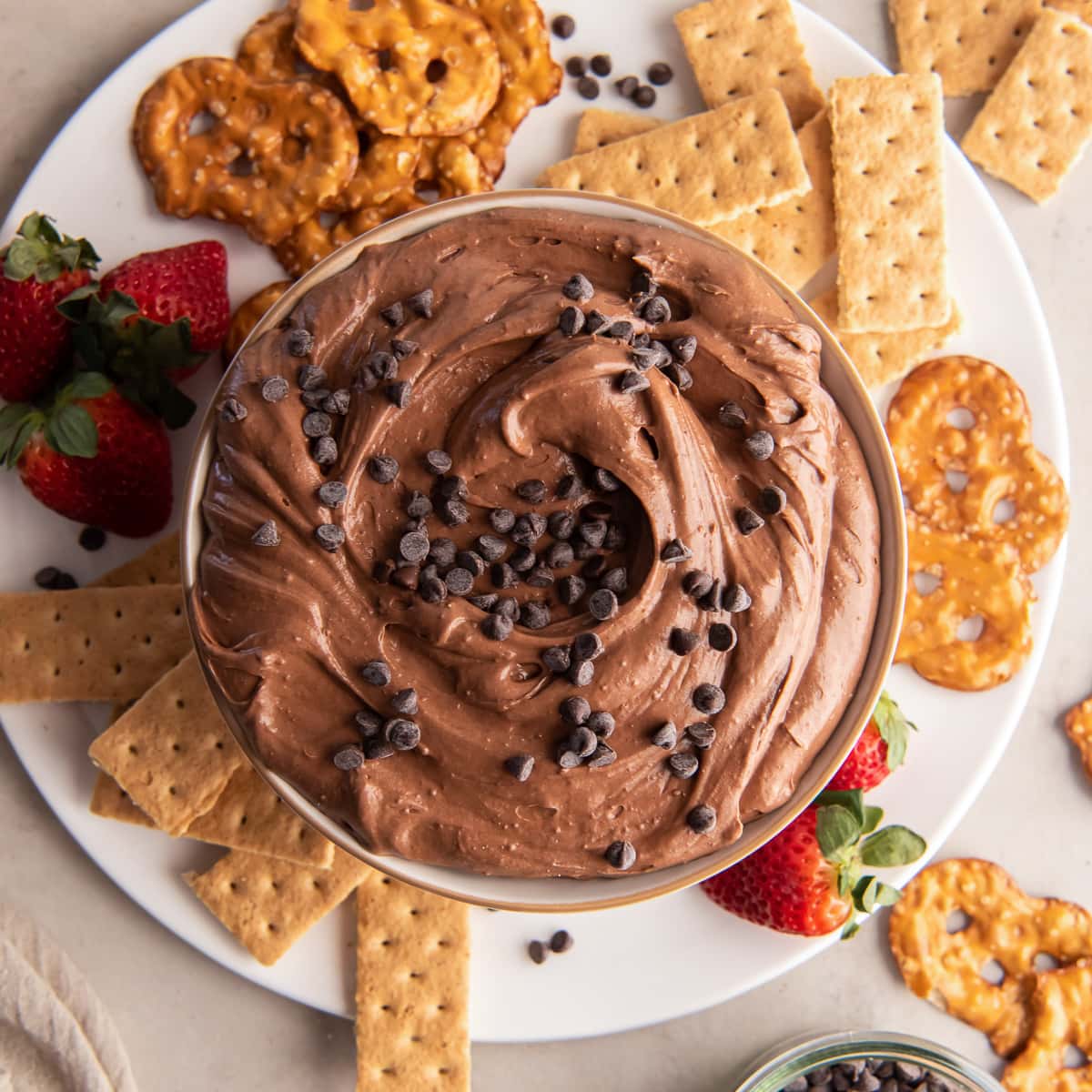 bowl of brownie batter dip on plate with pretzel thins and graham crackers.