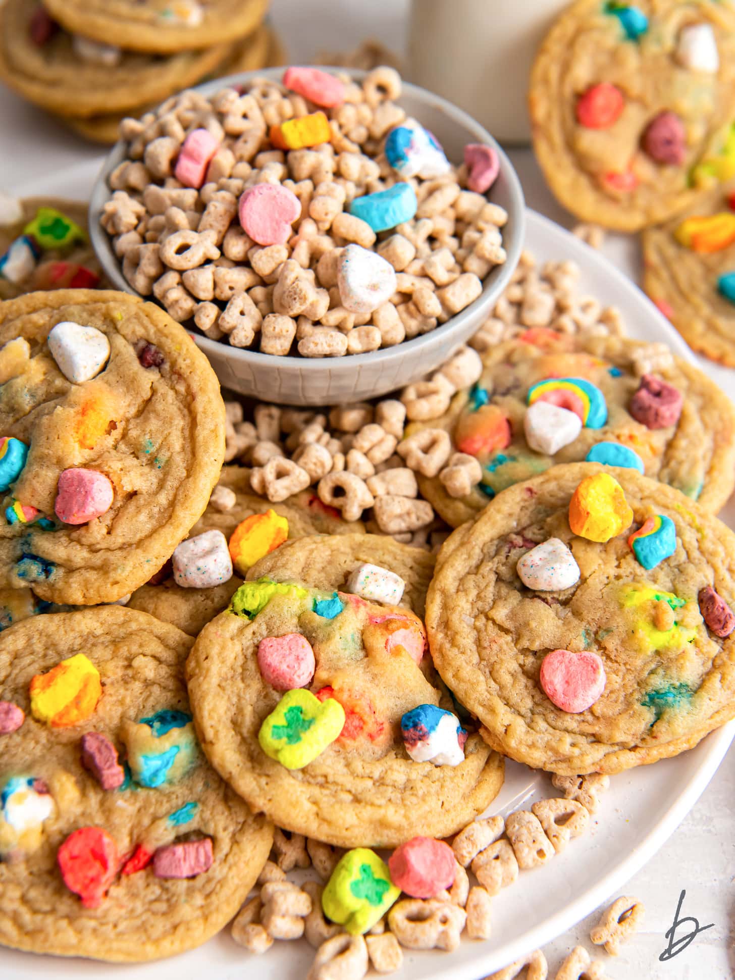 plate of lucky charms cookies next to bowl of cereal.