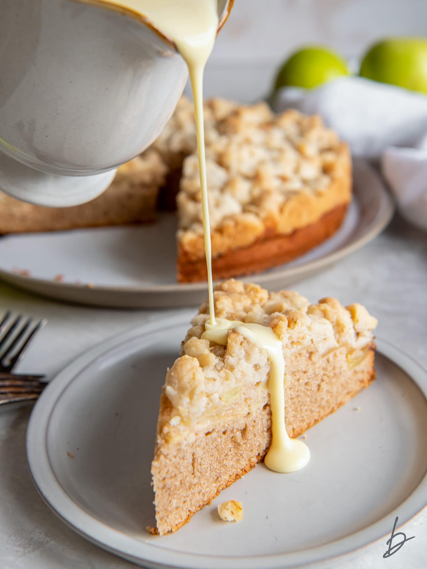 custard sauce poured on top of Irish apple cake on plate.