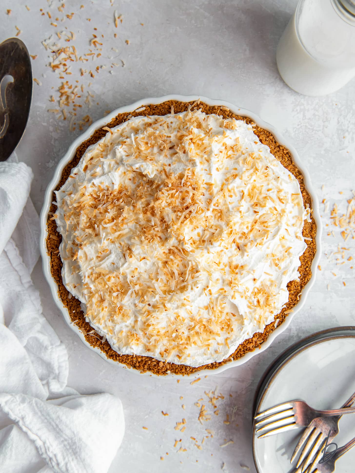 coconut cream pie with whipped cream topping and toasted coconut garnish.