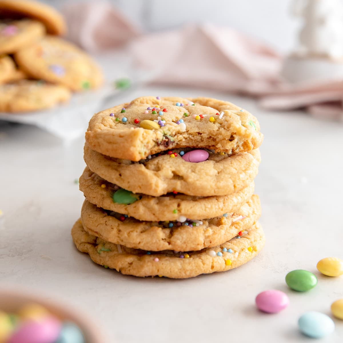 stack of easter M&M cookies and top cookie with a bite.