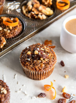 morning glory muffin with some shredded coconut and raisins next to it.