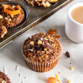 morning glory muffin with some shredded coconut and raisins next to it.