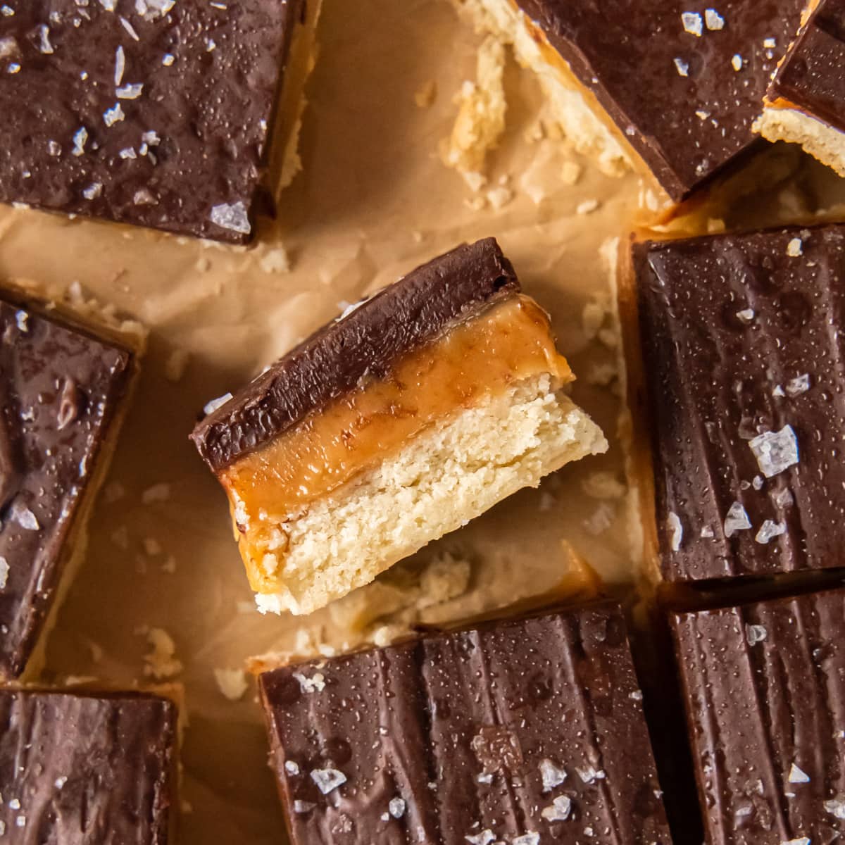 millionaire bar on its side showing layer of shortbread crust caramel filling and chocolate ganache topping.