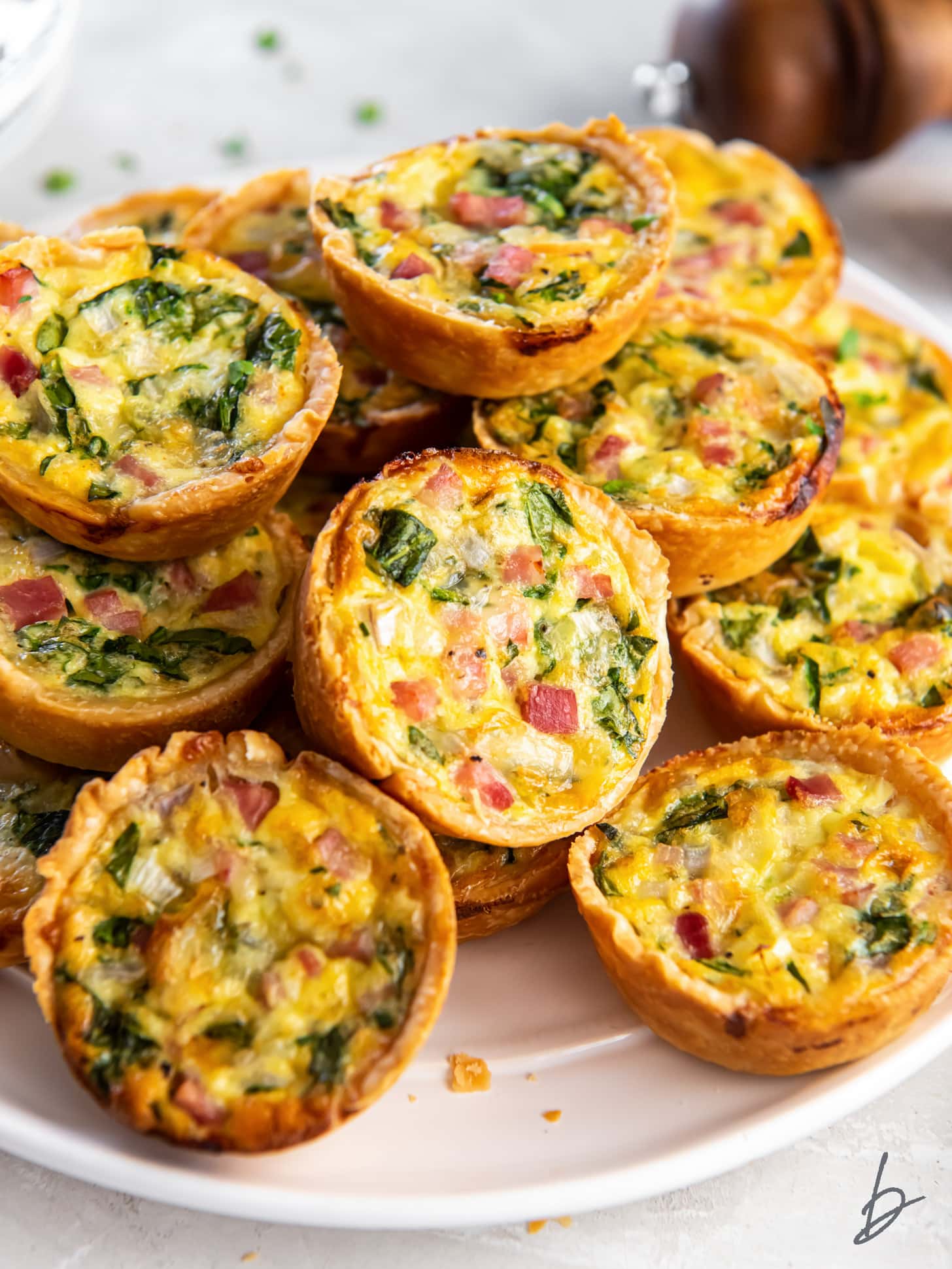pile of mini quiches on a plate.