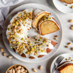 pistachio bundt cake on a plate with two slices cut off.