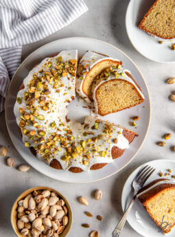 pistachio bundt cake on a plate with two slices cut off.