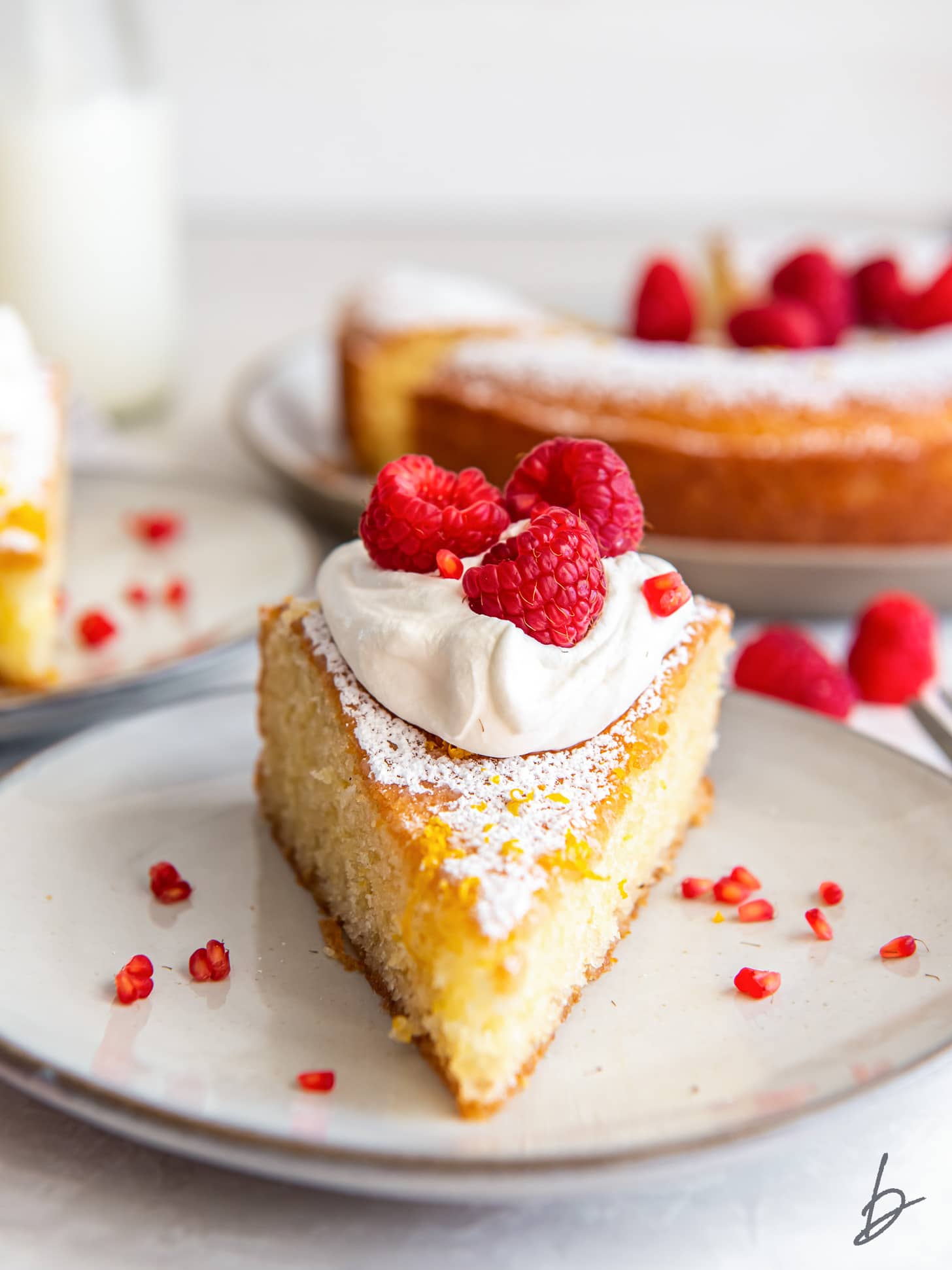 slice of french yogurt cake topped with whipped cream and raspberries.