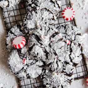 chocolate peppermint crinkle cookies on small wire rack with some peppermint candies.