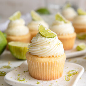 plate with a margarita cupcake with tequila lime frosting and lime garnish.