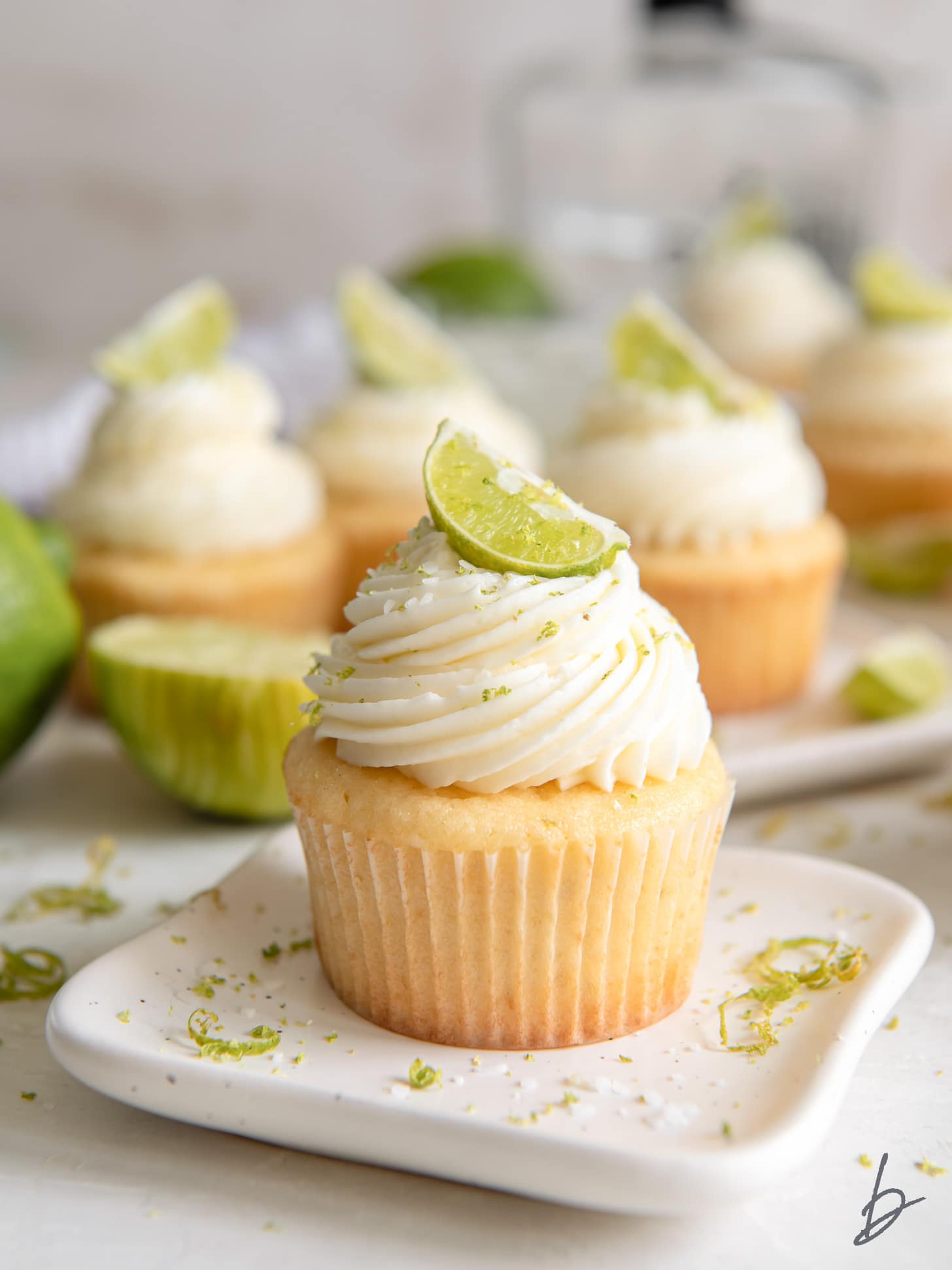 plate with a margarita cupcake with tequila lime frosting and lime garnish.