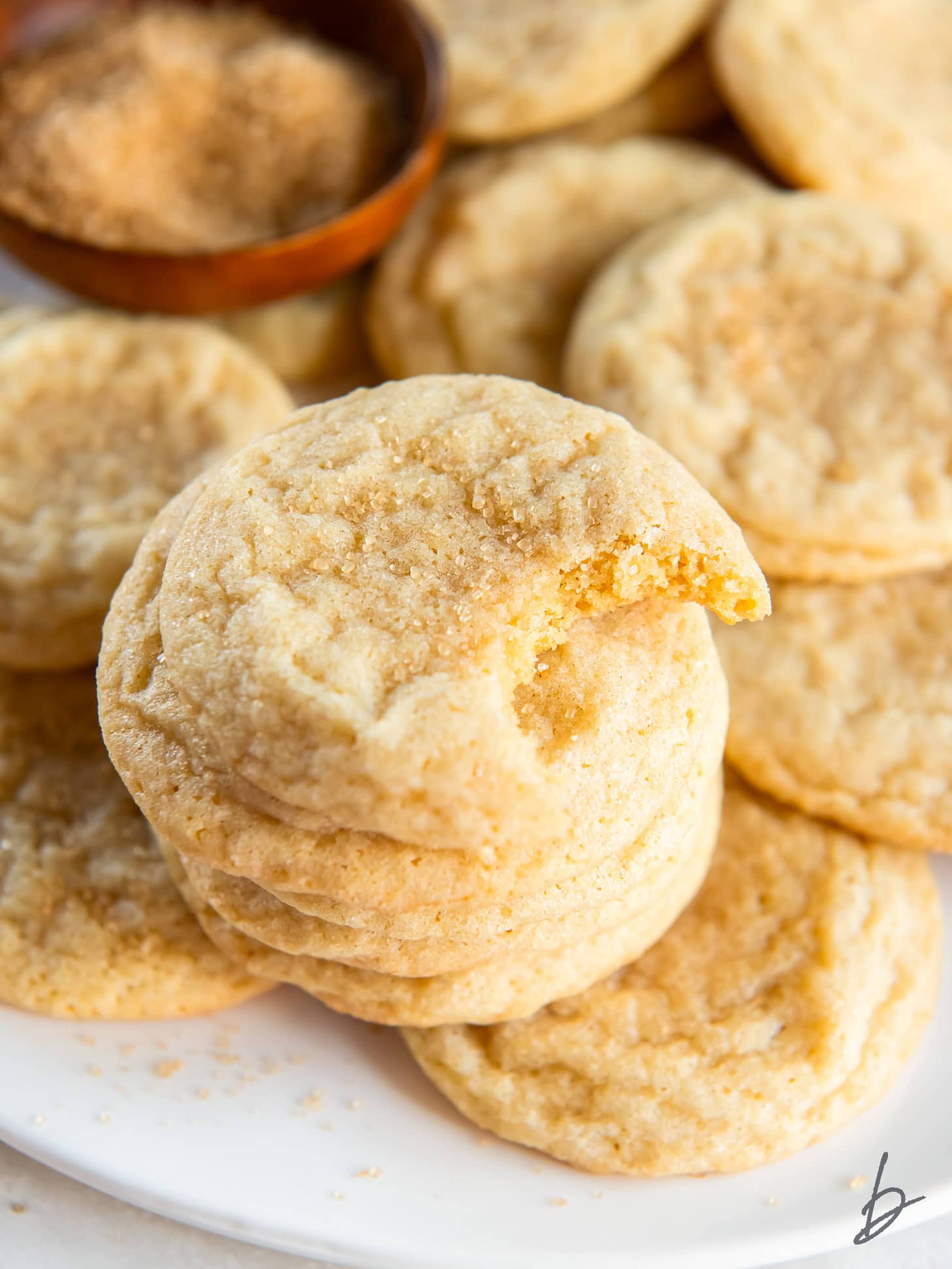 chewy sugar cookies in a stack and top cookie has a bite.