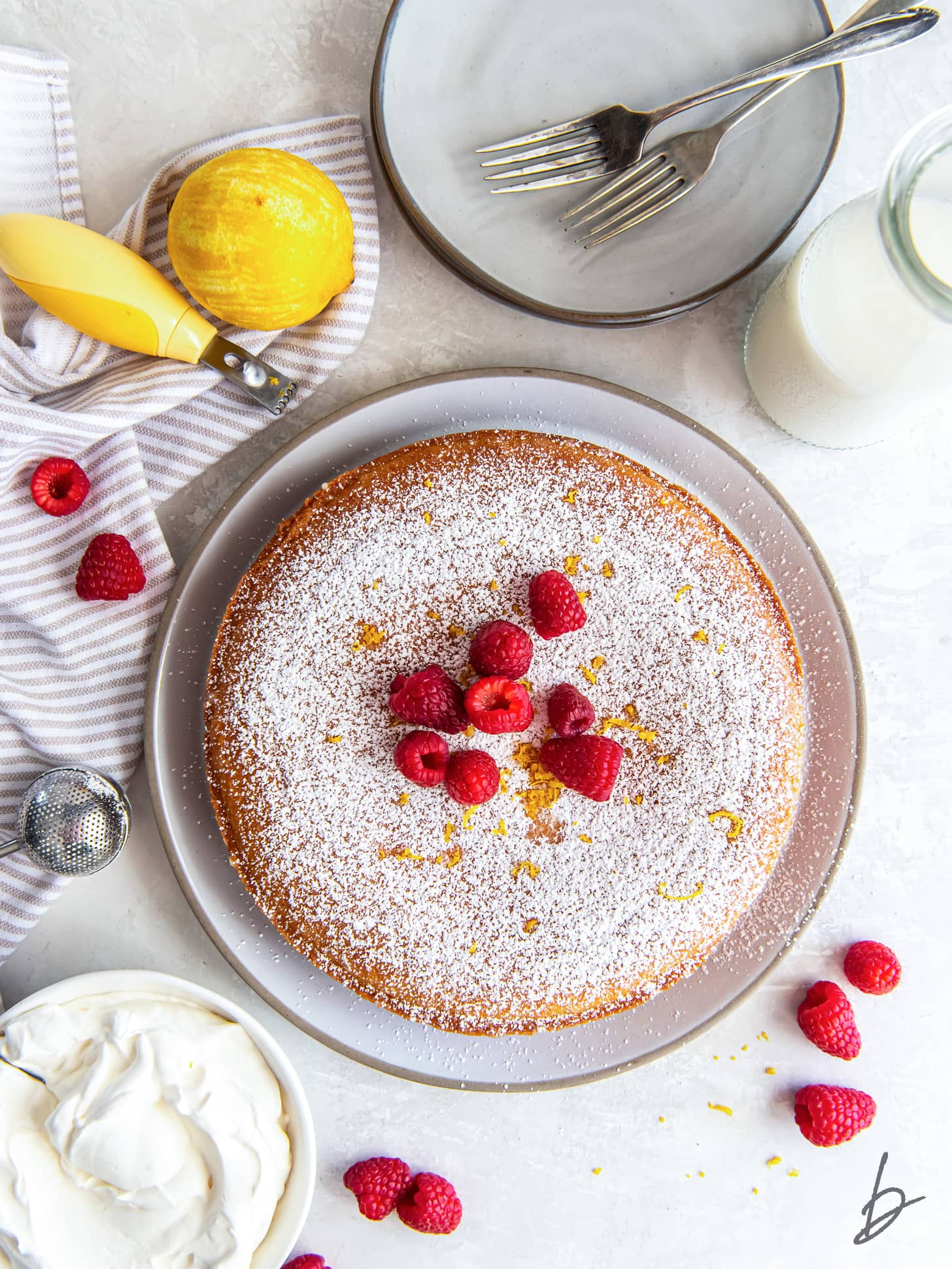 french yogurt cake with confectioners' sugar and raspberries as garnish.